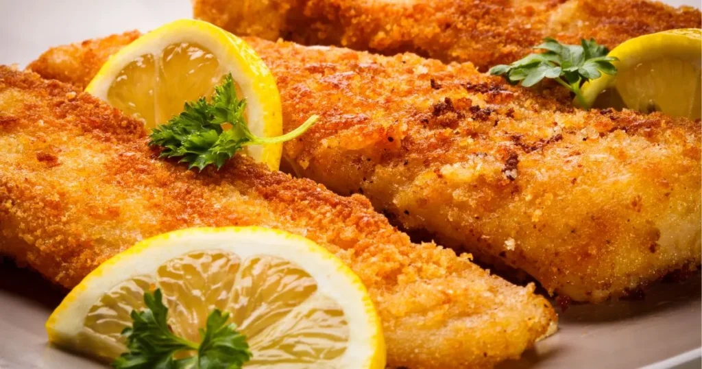 Southern Fried Fish: Irresistible Crispy, Soulful, and Simple to Make 4 Close-up of crispy Southern Fried Fish whiting fillets with a golden-brown crust, garnished with fresh parsley and lemon wedges.