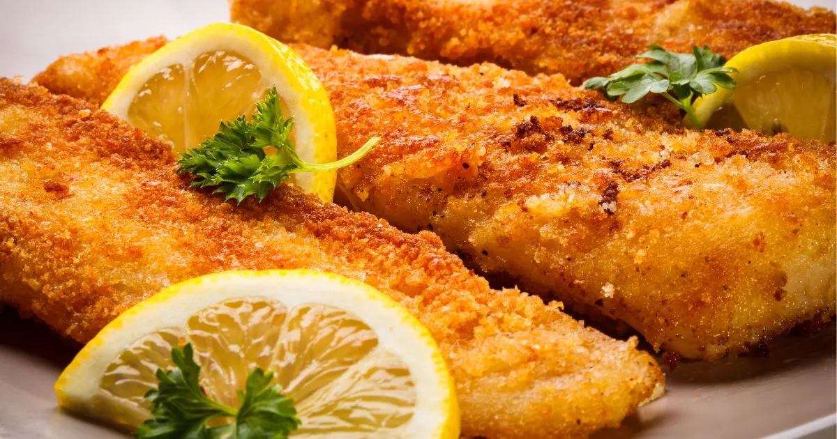 Close-up of crispy Southern Fried Fish whiting fillets with a golden-brown crust, garnished with fresh parsley and lemon wedges.
